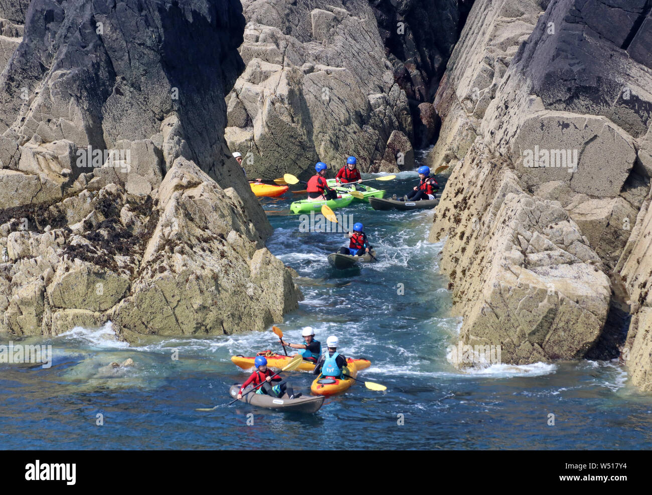 Gruppi in kayak intorno alle rocce sulla costa del Pembrokeshire Foto Stock