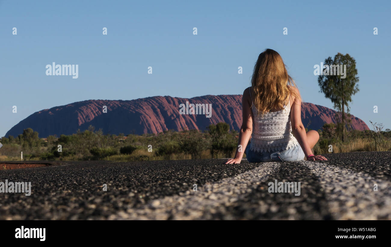 Turismo a Uluru o Ayers Rock in Australia centrale, l'enorme monolite di arenaria che è sacro agli indigeni australiani. Foto Stock