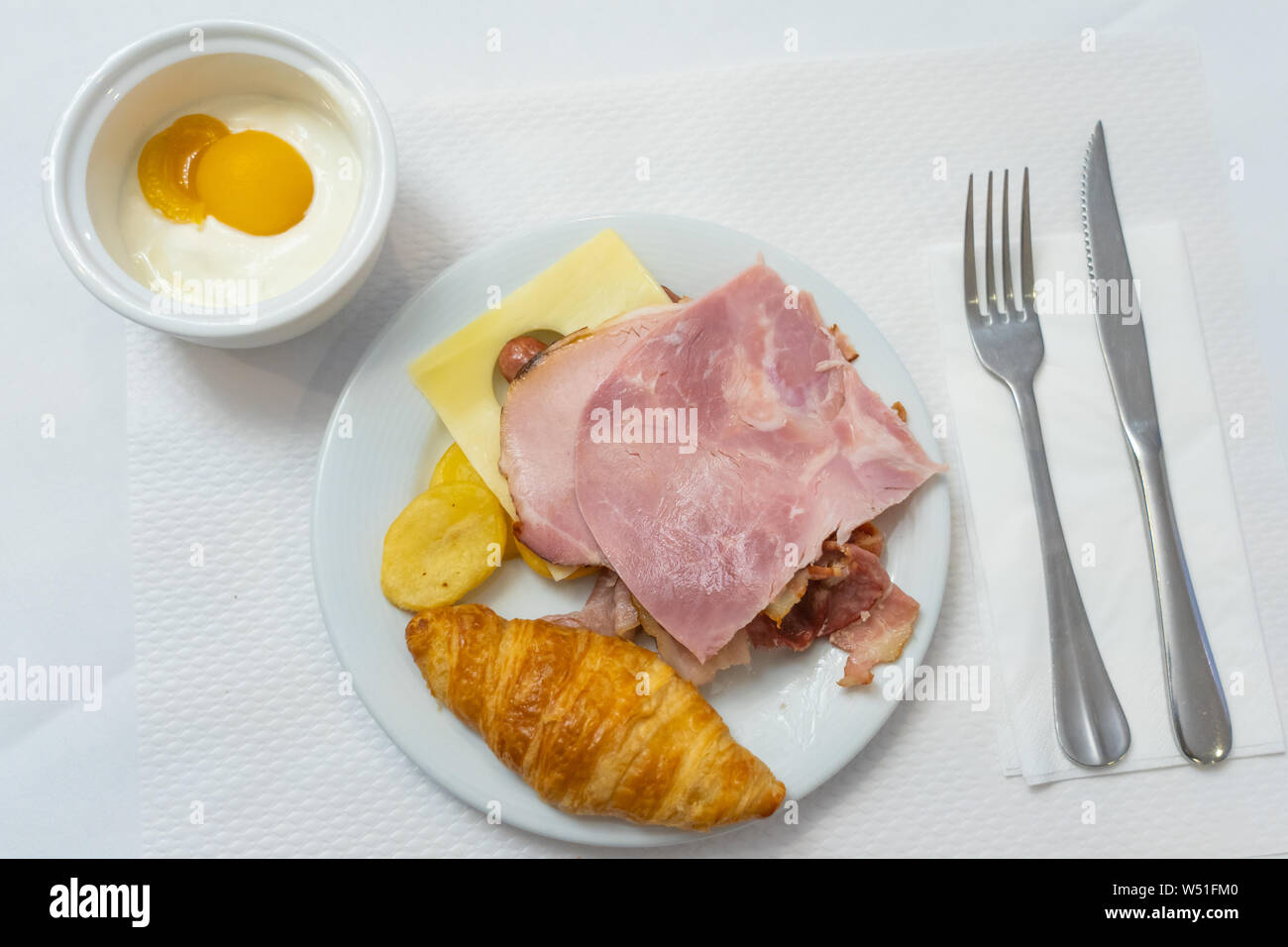 Croissant al burro con prosciutto formaggio e yogurt per colazione Foto Stock