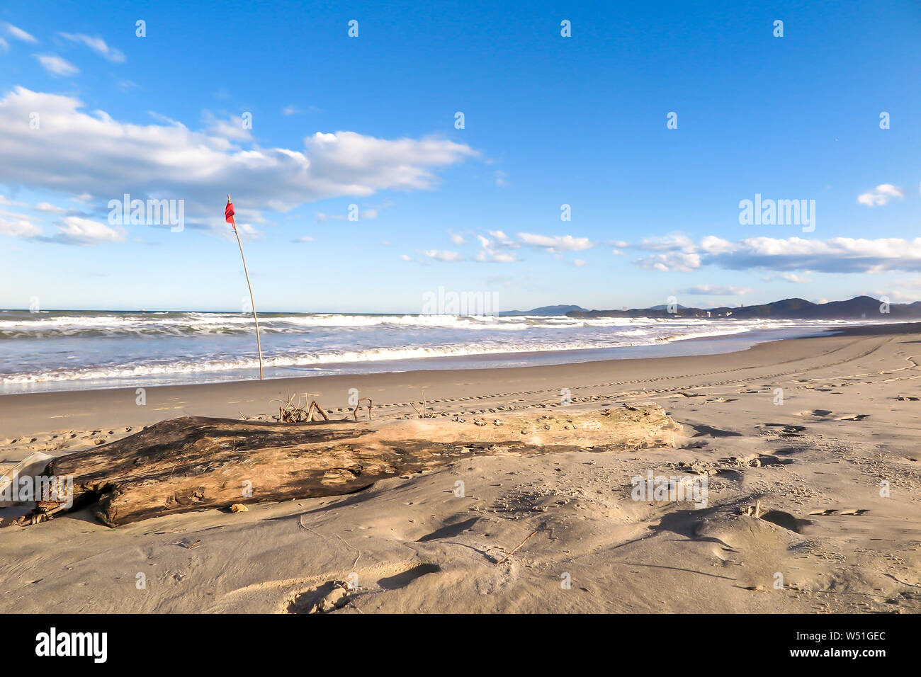 Navegantes beach nel tardo pomeriggio, con la bandiera rossa e mare mosso, cielo blu con nuvole Foto Stock