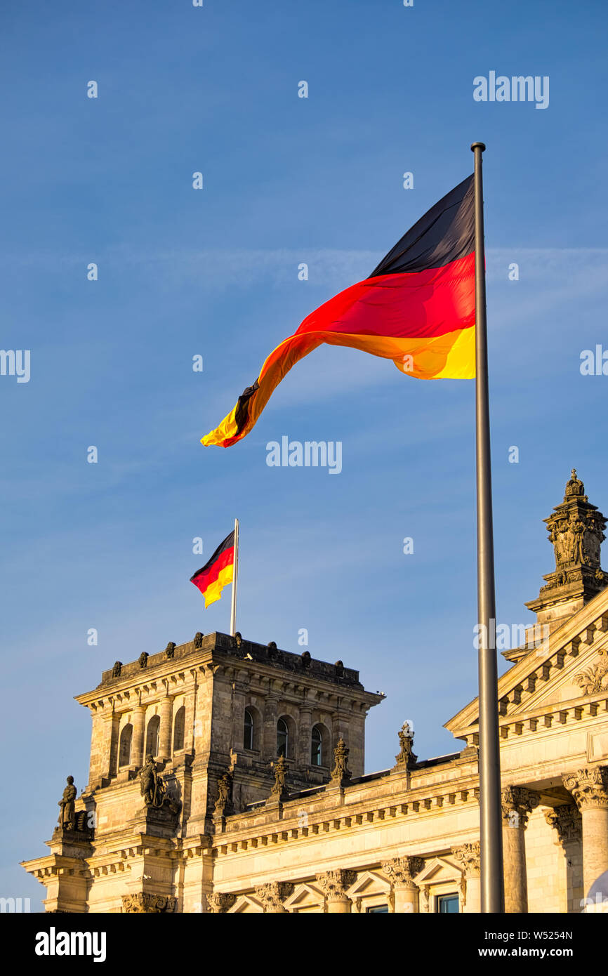 L'edificio del Reichstag di Berlino in Germania con la bandiera tedesca. Un famoso punto di riferimento e meta di viaggio per i turisti Foto Stock