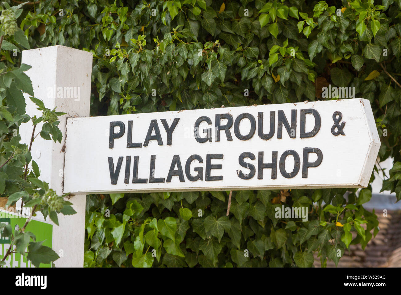 Un cartello in legno per il parco giochi e il negozio del villaggio nel villaggio di South Stoke, Oxfordshire, Foto Stock