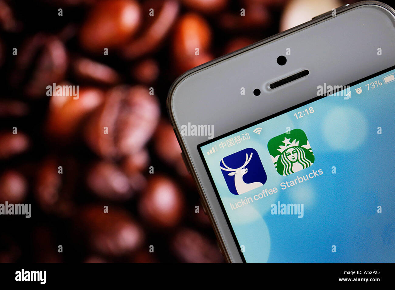 --FILE--un cinese telefono cellulare guarda le icone delle applicazioni mobile della Cina il nuovo marchio di caffè caffè Luckin, sinistra e Starbucks Coffee sul suo smartpho Foto Stock