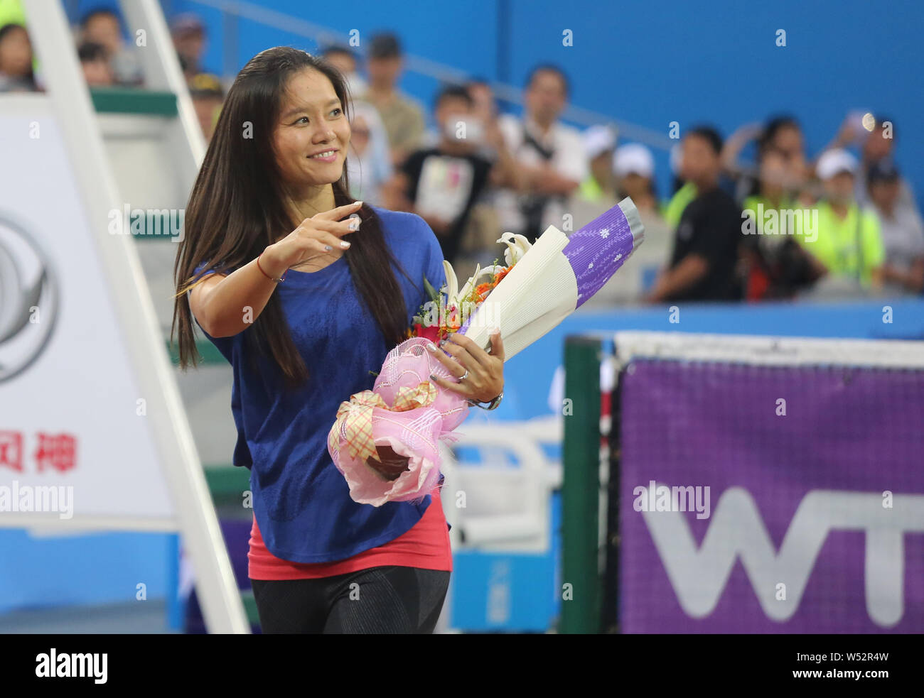 --FILE--cinese ritirato la stella del tennis Li Na onde per ventole a una breve cerimonia di pensionamento durante il 2014 WTA Wuhan Open Tennis Tournament a Wuhan City, Foto Stock