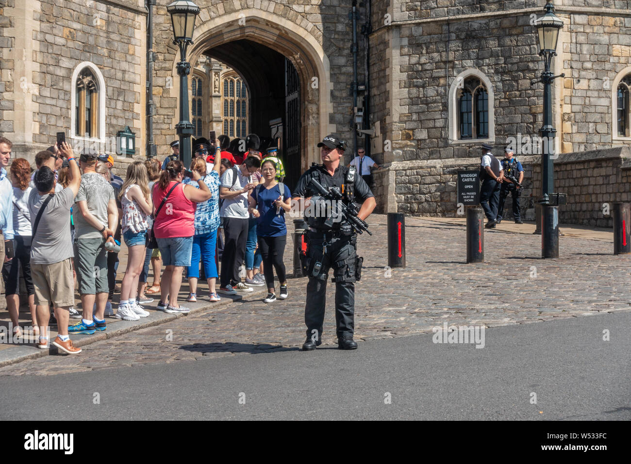 Armi da fuoco di un ufficio di polizia si erge al di fuori del Castello di Windsor con la sua mitragliatrice pronto durante la cerimonia del cambio della guardia. Foto Stock