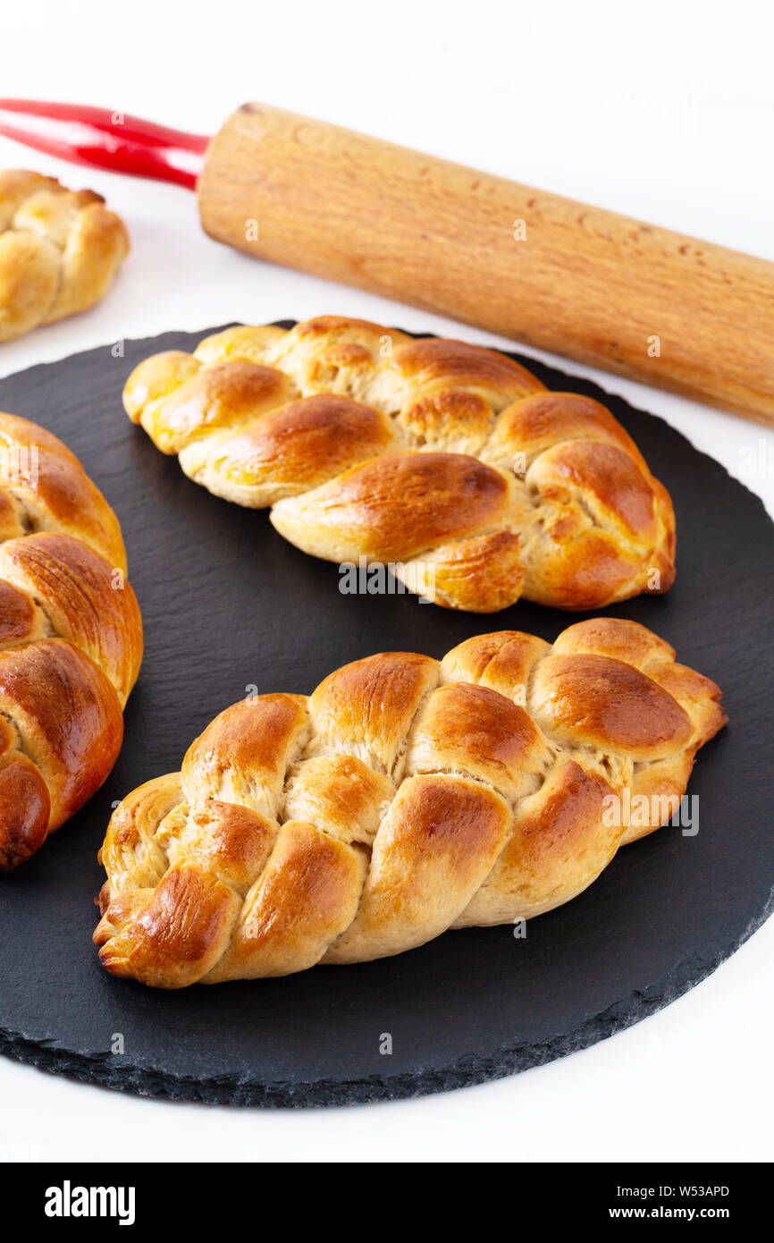 Cibo fatto in casa concetto pane fresco braid challah impasto su ardesia nera pietra con spazio di copia Foto Stock