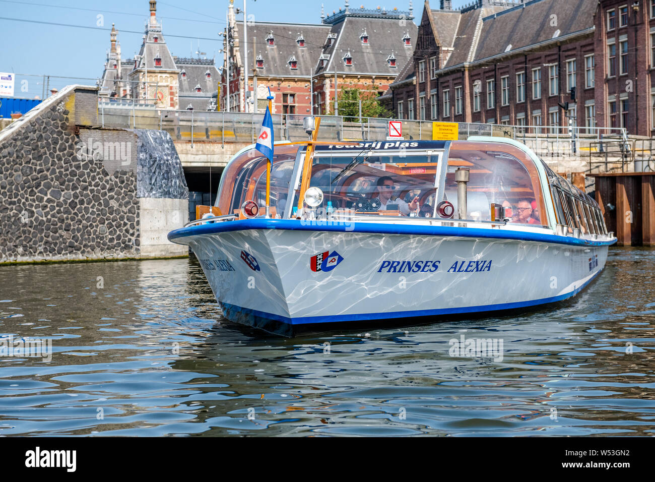I turisti prendendo un canal gita in barca sui molti canali intorno la città olandese di Amsterdam. Foto Stock