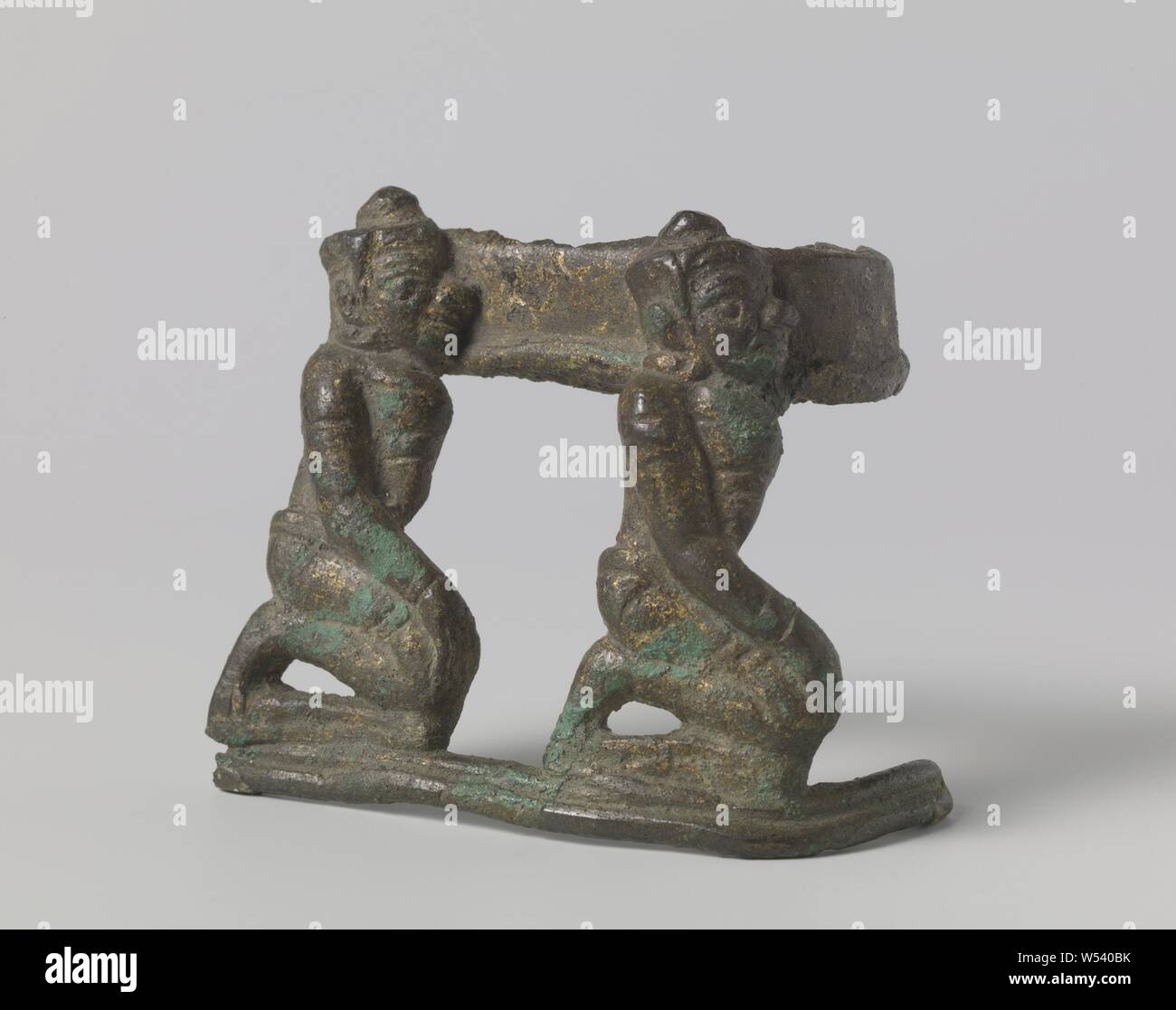 Frammento di una scultura, un frammento di una scultura con la rappresentazione di due asuras (demoni) seduto sulle ginocchia e trasportare qualcosa di pesante sulle loro spalle., anonimo, Cambodja, c. 1200 - c. 1300, bronzo (metallo), h 7,9 cm × W 8.9 cm × d 4.6 cm × h 9,3 cm × W 9.5 cm × d 5.3 cm Foto Stock