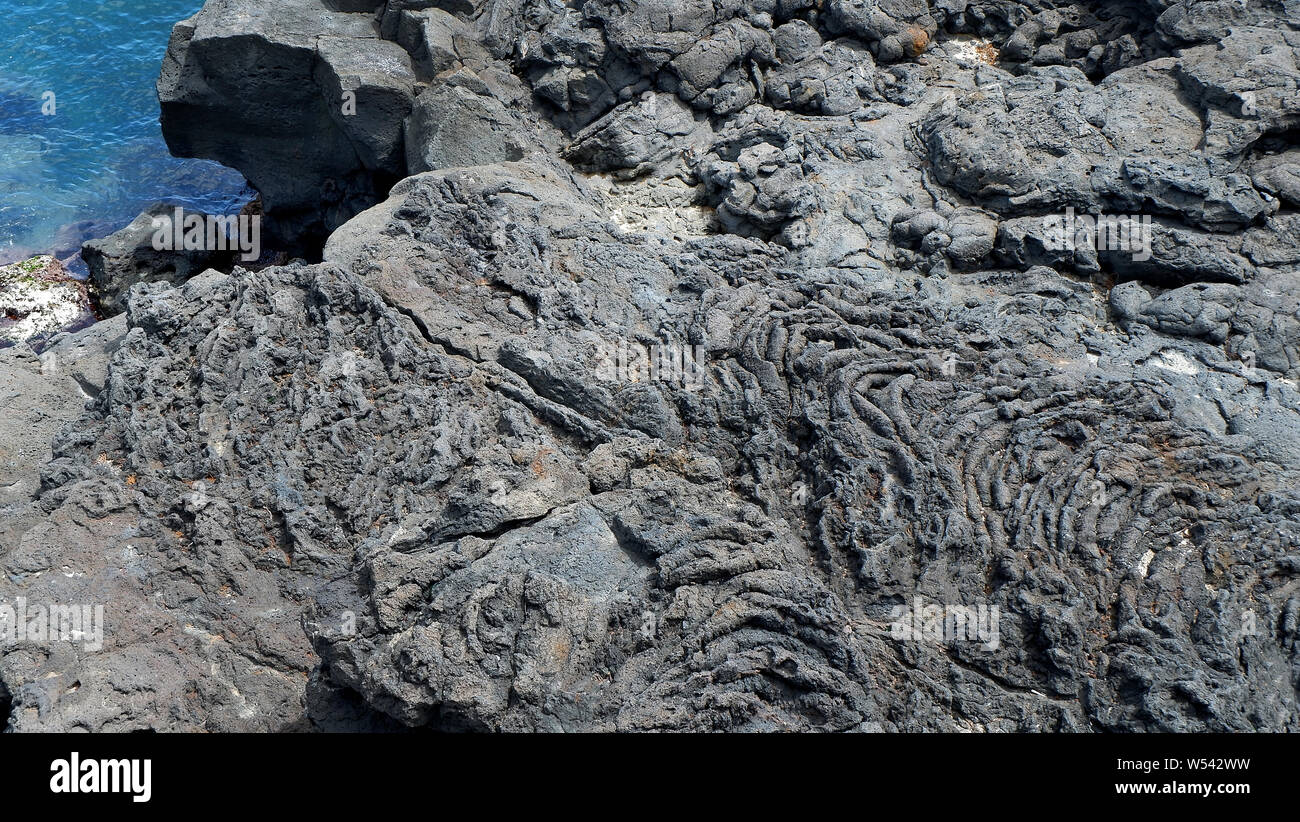La superficie della pietra vulcanica. Pietra nera dello sfondo. Rock texture. Pila di rocce sullo sfondo Foto Stock