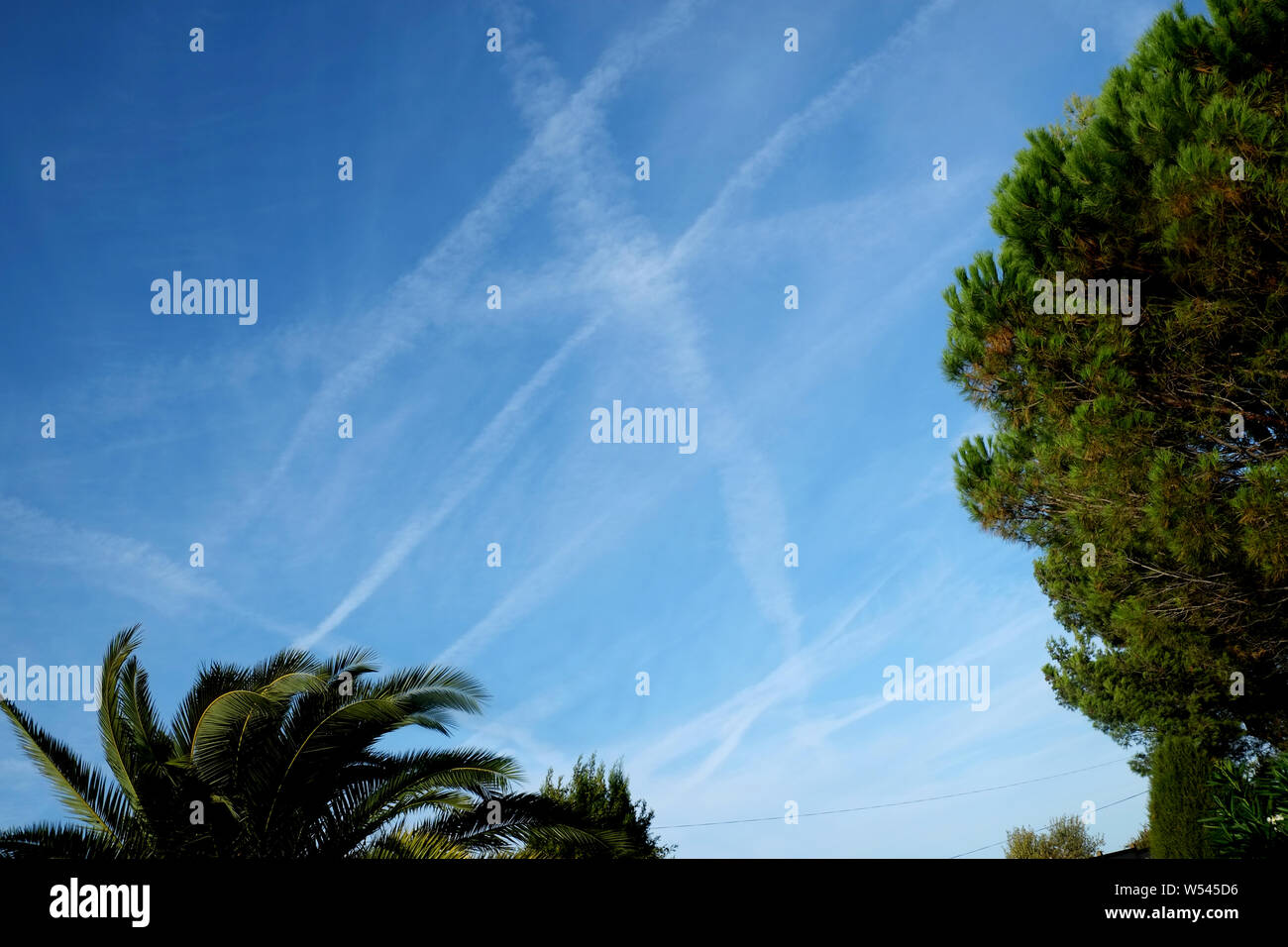 Sentieri di aereo in un cielo blu nel sud della Francia che mostra come occupato la zona è con il passare dei piani. Un settore travel Concetto di immagine. Foto Stock