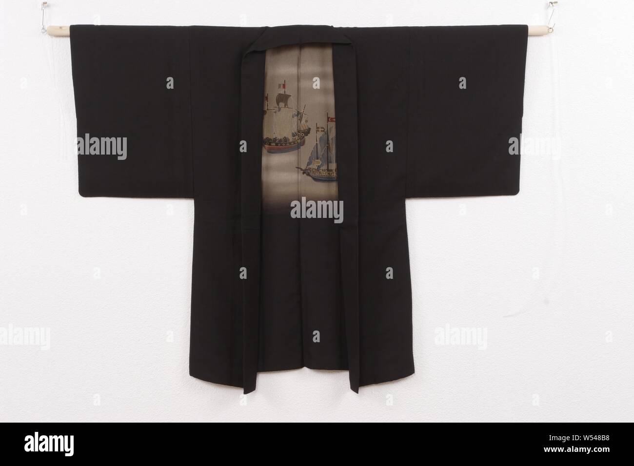 Gli uomini haori con due navi, Haori per un uomo con una decorazione sul rivestimento di due navi a vela, una basata sul modello cinese, gli altri europei. Nero seta greggia (tsumugi) con dipinti yuzen decorazione. Ricamati a singola cresta di famiglia (MON) da wisteria (Fuji)., anonimo, Giappone, 1920 - 1940, seta, pittura, h 131 cm × W 100 cm Foto Stock