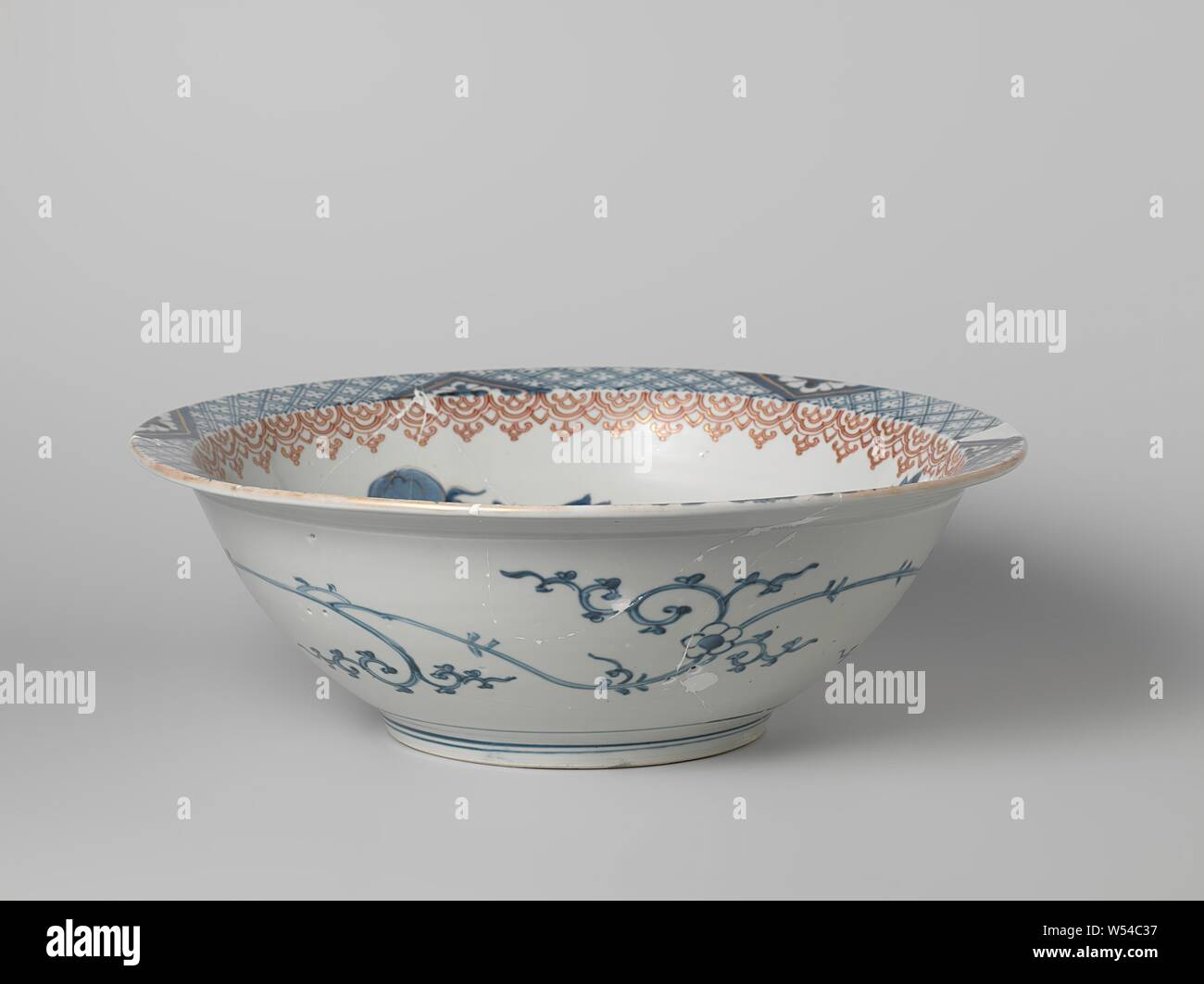 Ciotola con shishi e butterfly vicino a un ramo peonia, grande ciotola di porslein con una cornice piana, dipinta in underglaze blu e sullo smalto rosso e oro. L'interno con un shishi (lion dog) e una farfalla in corrispondenza di un ramo peonia, la parete con una fascia con motivi ruyi. Il bordo interno con igienico lavoro interrotto da triangoli con un cut-out fiore stilizzato. Un fiore di continuo la linea sulla parete esterna. Il vaso è stato rotto. Imari., anonimo, Giappone, c. 1675 - c. 1725, Edo-periodo (1600-1868), porcellana (materiale), smalto, cobalto (minerale), oro (metallo), la vetrificazione, h 13.7 cm d 40,1 cm d 17,6 cm Foto Stock