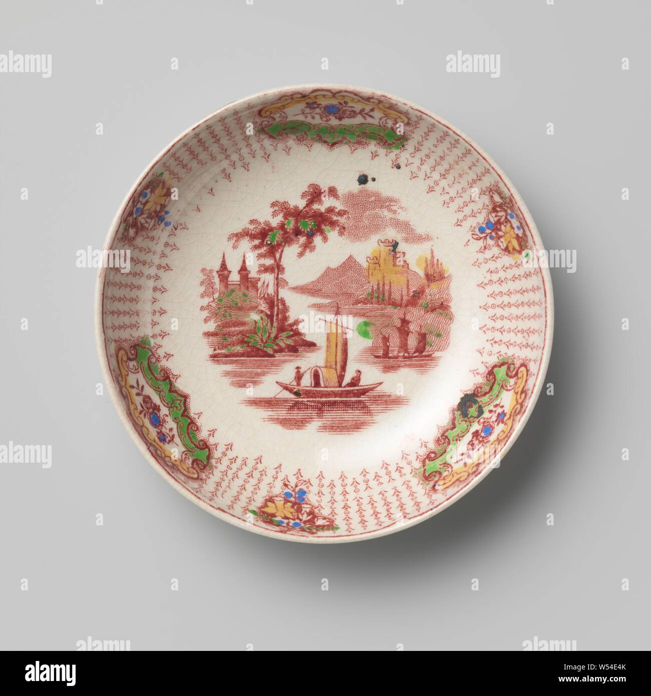Piatto di hard-sparato terraglia, ammenda creamware con trasferimento, piatto rotondo di hard-sparò di coccio con trasferimento multicolore. L appartamento ha un'immagine di un paesaggio fluviale con una barca. Il bordo ha tre medaglioni con fiore spray e tre mazzi tra una fondazione di stilizzata rami verticali. Il piattino appartiene a una tazza e tre uguali le tazze con piattini, anonimo, Inghilterra, c. 1830 - c. 1850, terraglia, h 3.0 cm × d 12,5 cm Foto Stock