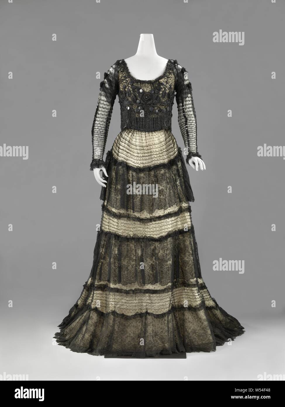Abito vestito, costituito da un mantello e di due diversi corpi, vestito di  pizzo nero su una crema di indumento intimo in raso, costituito da due  corpi (a,b) e un ampio mantello (