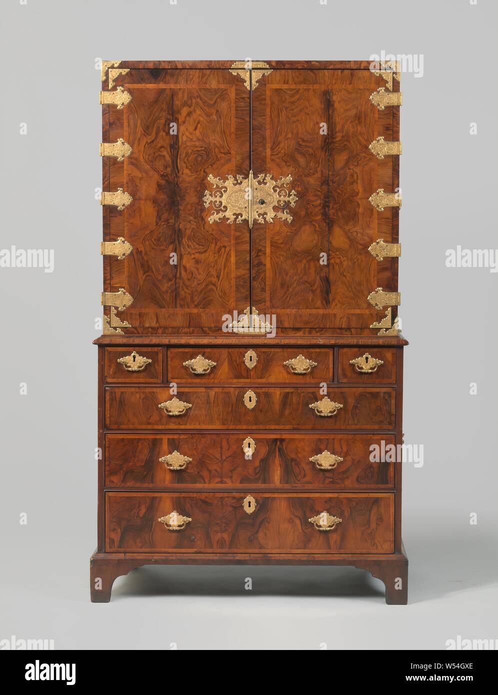 Armadio incollati con burr walnut, Cabinet incollati con burr walnut su un nucleo in legno di quercia, divisi in inferiori e superiori armadietto, decorato con le piastre di bloccaggio, angolari, cerniere e trattori con piastre di incisa, placcato oro rame forgiato. Rame dorato le maniglie sui lati anche con piastre. L'armadio superiore è dotato di due porte anteriori, dietro la quale 12 cassetti di diversa larghezza, con i trattori e le piastre come all'esterno. Il telaio è dotato di tre cassetti su tutta la larghezza e alla sommità tre cassetti più piccoli. I piedi sono tagliati in corrispondenza degli angoli., anonimo, Gran Bretagna, c. 1675 - c. 1700, di legno (materiale vegetale Foto Stock