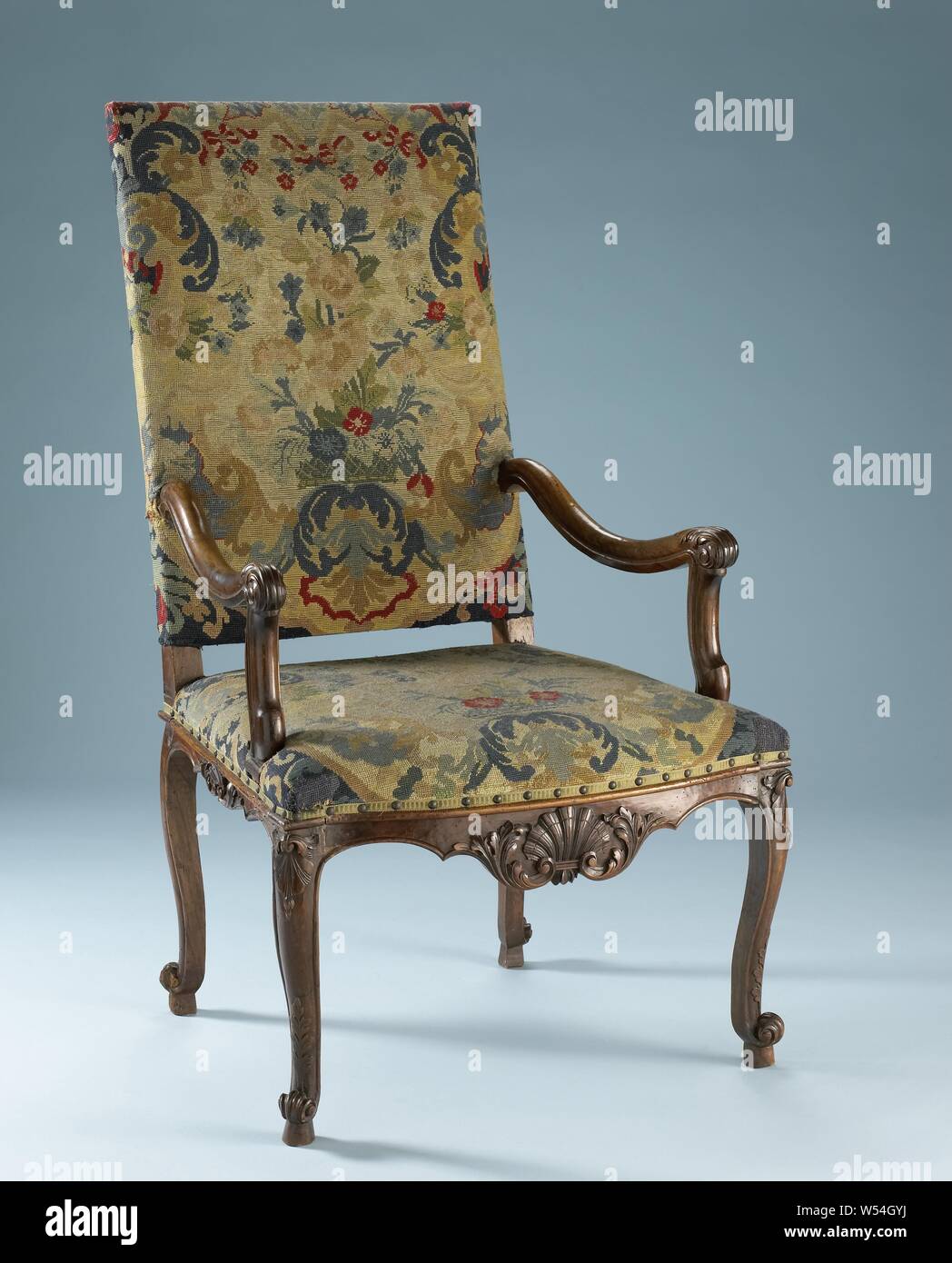 Poltrona in noce con petit-punto selleria, sedia in noce con petit-punto selleria e rovere indietro posti e le zampe posteriori. Le sedi si appoggiano su S angolata la conformazione delle gambe che si fondono nel telaio del sedile. Le gambe anteriori hanno una voluta con una foglia permanente motif e un motivo di shell al di sopra del rigonfiamento. Parte anteriore e laterale linee del sedile sono decorate con un guscio e foglie di acanto. Il bracciolo puntoni Unisci in un incavo di braccioli, terminando in acanto voluta. La selleria mostra motivi di vasi di fiori e bouquet., anonimo, Paesi Bassi, c. 1700 - c. 1725, di legno (materiale vegetale), noce (legno), ricamare Foto Stock