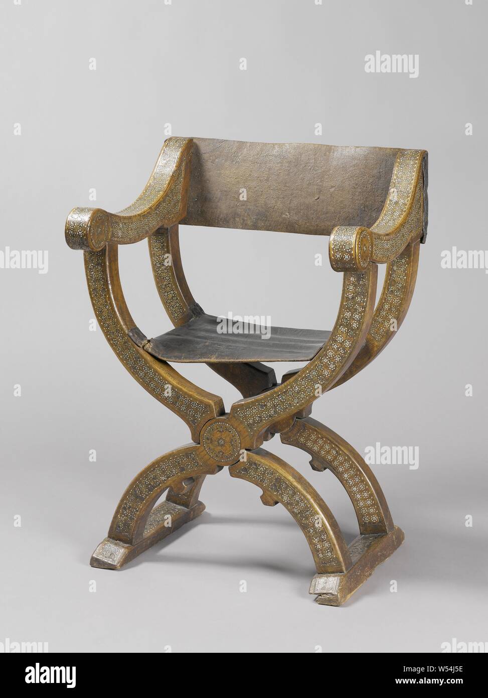 Sedia pieghevole realizzato in legno di olmo, con pelle Schienale e sedile, e appoggiata sui semi-circolare di gambe, che sono collegati a semi-Montanti circolari. Le gambe sono su steli di collegamento. I braccioli sono leggermente scavato, fine in volute e aumento del ritorno di posti. La parte anteriore delle gambe e dei posti, la sommità delle rocche e i tre lati dei braccioli presentano tracce intarsiato, costituito da piccoli ottagoni con stella e diamanti, eseguito nella tecnica certosina in osso, madreperla e legno., anonimo, Noord-Italie, 1500 - 1600, il legno (materiale vegetale), olmo (legno), pelle, ossa (materiale), madre Foto Stock