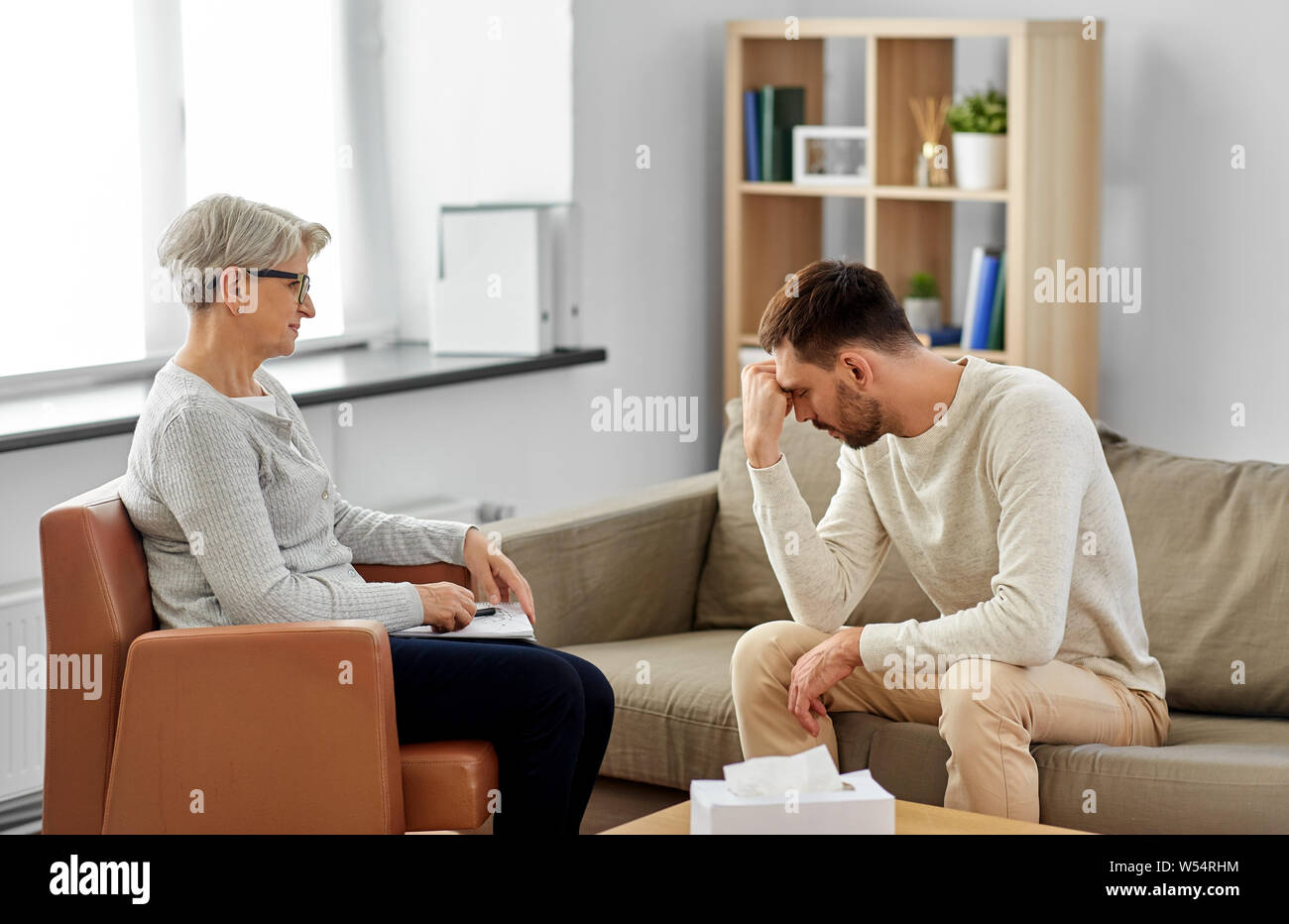 Senior donna psicologo e triste uomo paziente Foto Stock
