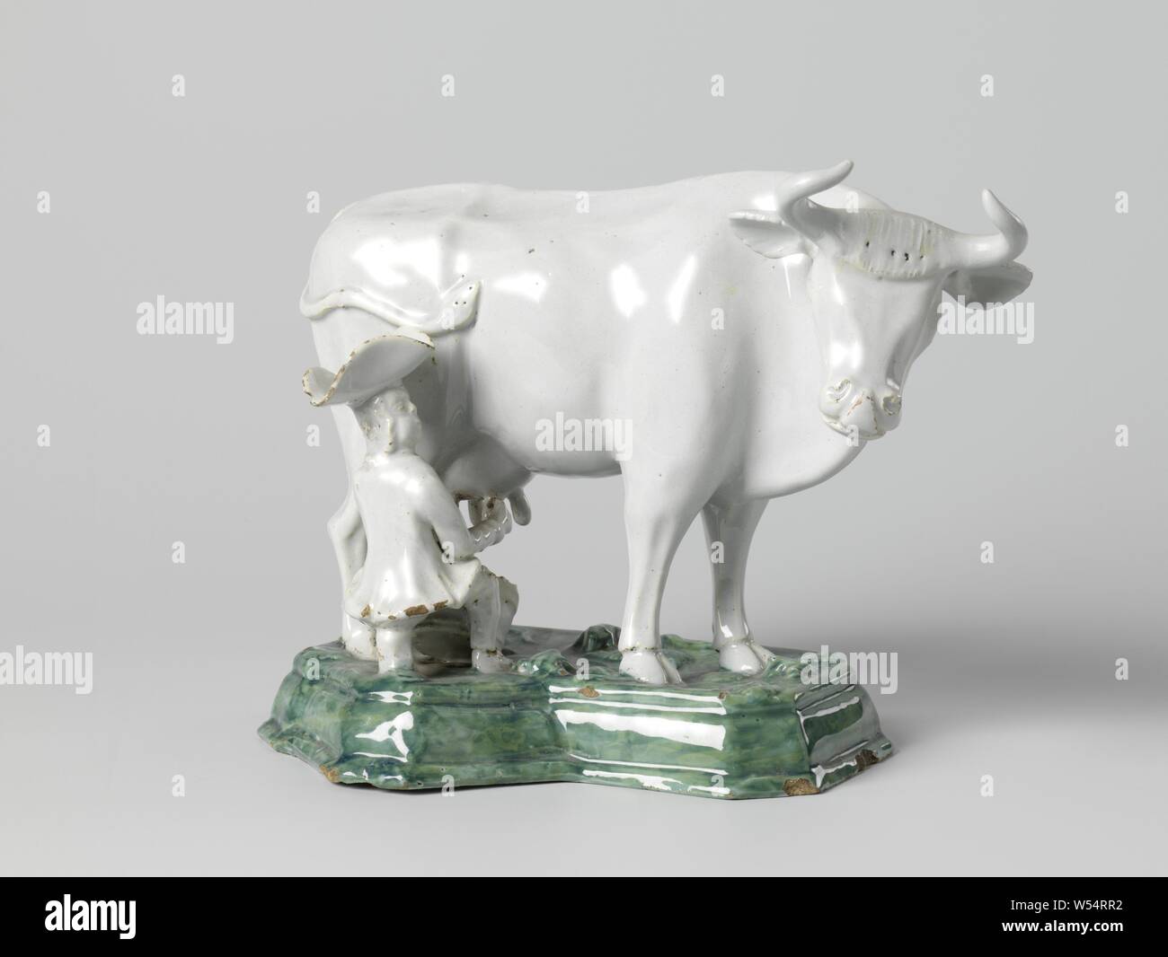 Mucca con la stella di latte, sul piedistallo verde, la scultura di maioliche. Una mucca non decorato sorge su un dipinto di verde il piedistallo. Sul lato destro della mucca è un uomo di mungere le mucche. L'uomo si usura a tre punte stitch., anonimo, Delft, c. 1750 - c. 1780, terraglia, stagno smalto voetstuk, h 18 cm × W 24 cm × d 13,5 cm Foto Stock