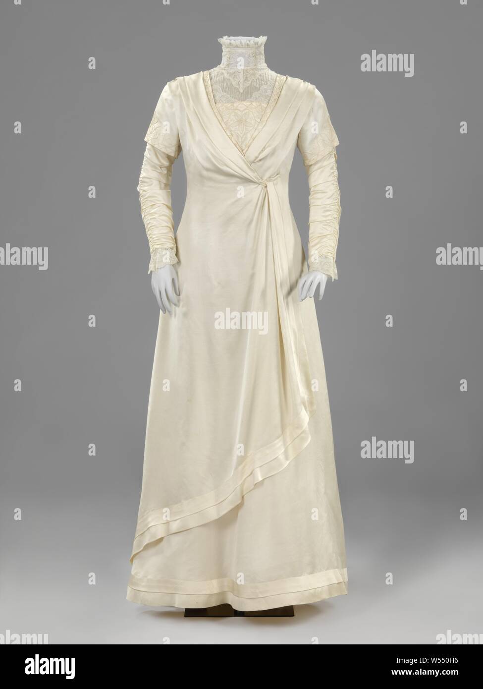 Abito da sposa con ricamate e increspato manicotti doppia, bianco satinato abito nuziale con sguardo de soie e merletto a fuselli, costituito da una tonaca (a), un underskirt (b) e corrispondenti pattini (c, d) di bianco glacé pelle, white satin abito nuziale con sguardo de soie e il merletto a tombolo, un underskirt (b) e corrispondenti pattini (c, d) di bianco pelle glacé. Modello (a): accappatoio princesse o Tanagré enne con un trascinato-sul sentiero. Anteriore: la chiusura è nascosto sotto un diagonalmente ribaltato la tunica di forma-wrap. Profondo scollo a v con un basso cardigan in raso e un elevato secondo cardigan da sguardo de soie e pizzi (XVIII secolo Mechelen Foto Stock