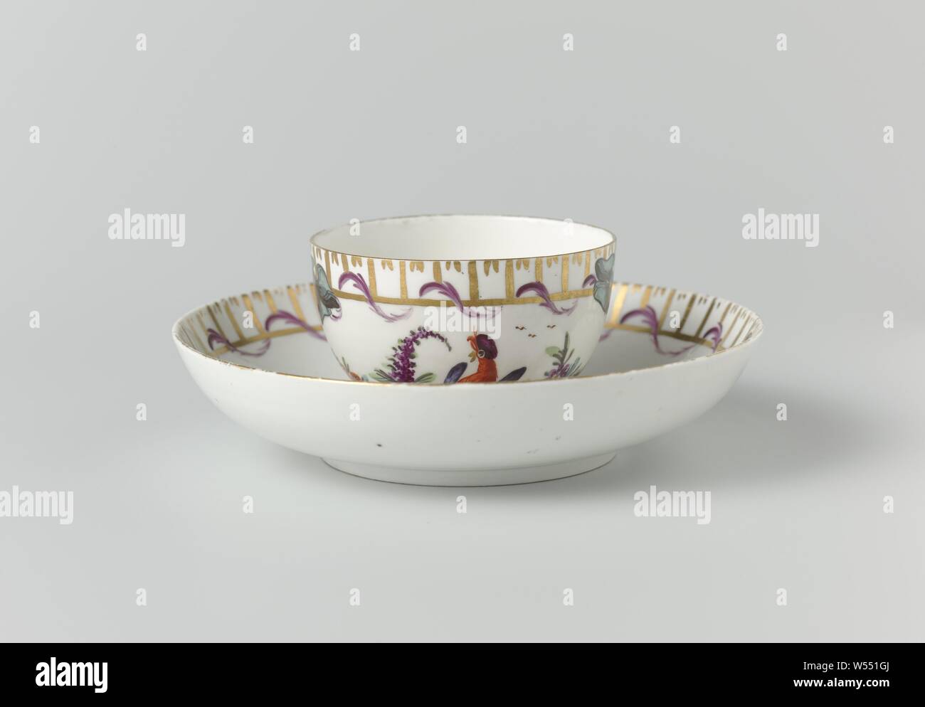 Tazza e piattino tazza e piattino, dipinto policromo con uccello sul ramo, testa senza orecchio e piattino e multicolori dipinte con un uccello su un ramo su un terreno. Intorno ai bordi di una banda dorata e una banda di strisce verticali avvolto con una foglia garland. Contrassegnato con due spade incrociate con tre sfere in underglaze blu., Weesper porseleinfabriek, Weesp, c. 1769 - c. 1771, porcellana (materiale Foto Stock