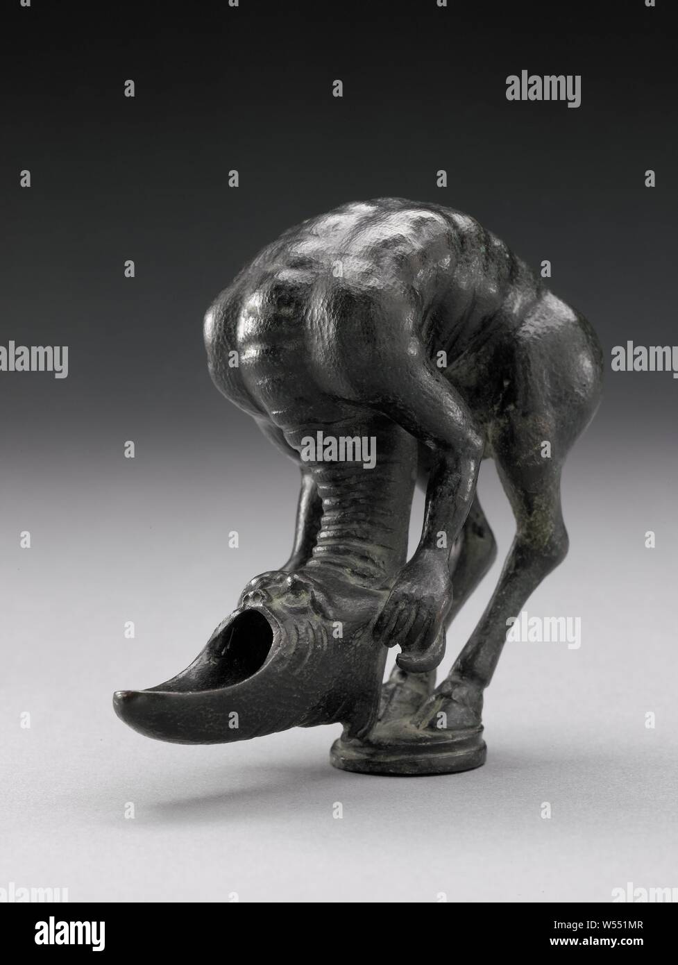 Fantasy animale (olio lampada?), su una base circolare, l'animale si erge su entrambe le zampe posteriori con zoccoli di split. Il fortemente curvate indietro con pronunciata spina dorsale si fonde nel rivolta verso il basso, avanti-piegato lungo collo. L'animale mantiene il posto orizzontale testa con entrambe le gambe anteriori, che ha una mascella inferiore e le corna che sporge in avanti e mostra una espressione selvaggia. Il suo goatee colpisce la terra superiore, la sua coda altalene., Arent van Bolten (attribuito a), Zwolle (eventualmente), c. 1610 - c. 1630, bronzo (metallo), laccature h 10.5 cm × W 10 Foto Stock