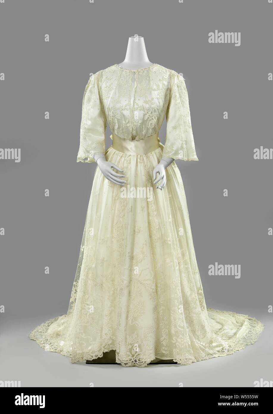 Pizzo abiti da sposa, abito da sposa dal lato di applicazione con giardino trofei in medaglioni, Tailored trascinare vestito da Bruxelles lato applicazione, con chiusura. Il corpo ha un alto scollo rotondo, lembi di spallina e tre quarti maniche a pagoda. Il mantello è di clocking presenta una spaccatura sulla parte anteriore e un giro di pista. I motivi sono realizzati in pizzo con merletto ad ago di cucitura decorativa - Bruxelles duchesse - che è appliqued sulla macchina di tulle. La linea del collo è un arco con un 'giardino trophy" costituito da un giardino hat, del pastore e del personale rastrello. Questo 'Trofeo' è ripetuta in cinque grandi medaglioni lungo Foto Stock