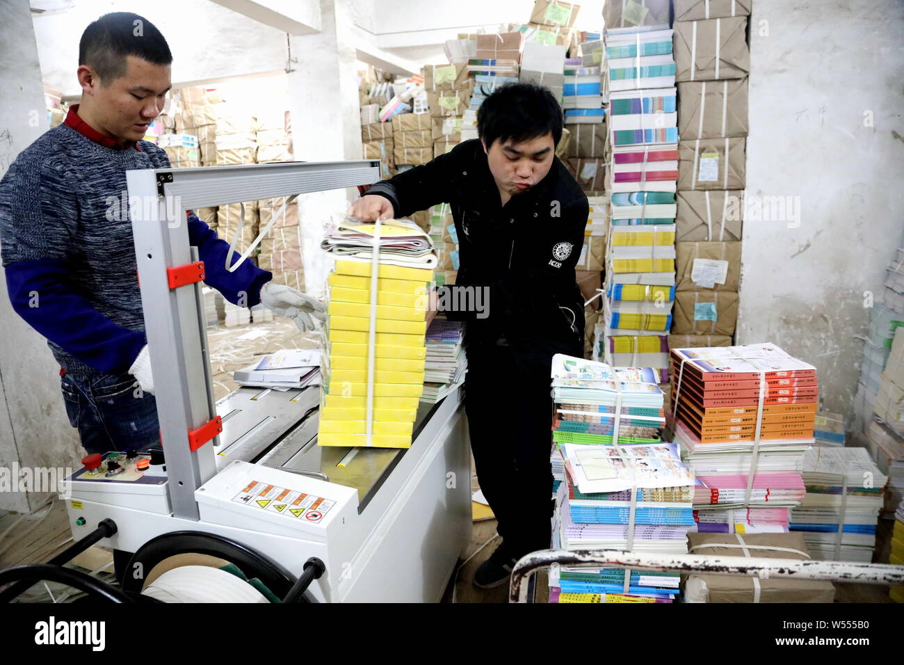 I membri del personale organizzare i nuovi libri di testo per essere inviati alle scuole per la nuova imminente semestre di Xinhua Bookstore di Quanzhou county, della città di Guilin, sud Foto Stock