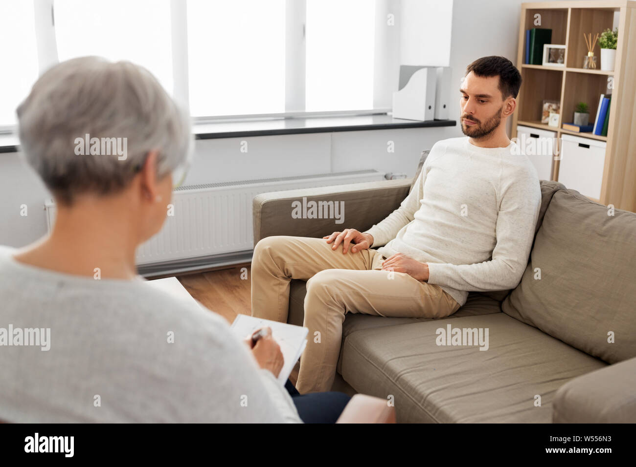 Senior donna psicologo e triste uomo paziente Foto Stock