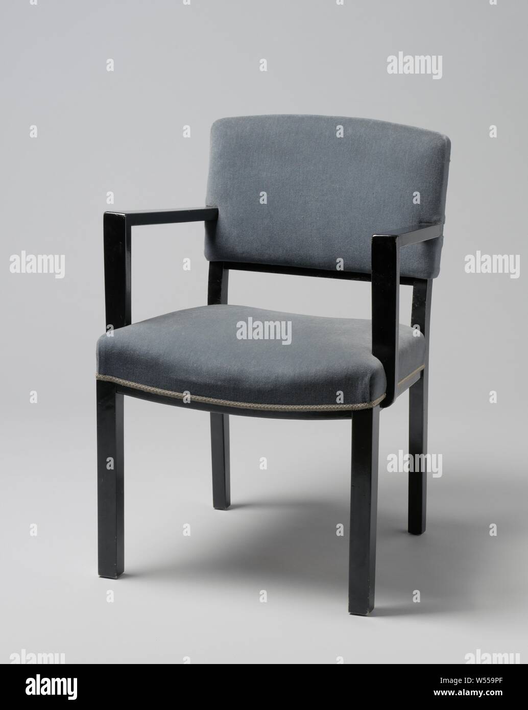 Poltrona con braccioli angolare e coperto con striscia blu, poltrona di nero laccato legno poggiante su quattro quadrati di gambe. Le zampe anteriori sono diritte e le zampe posteriori sono leggermente piegati e continuare nella parte posteriore POST. Il sedile è regolato in quattro linee le due linee laterali della quale sono dritte e la parte anteriore e la parte posteriore tubazioni piegate. La soglia inferiore dello schienale viene piegato. Piatto braccioli angolare correre verso il basso dal centro dello schienale e il resto davanti e non in linea con le gambe anteriori, sul piatto puntoni che sono parzialmente attaccata e in parte contro il sedile. Sia i corrimano e il sedile sono Foto Stock