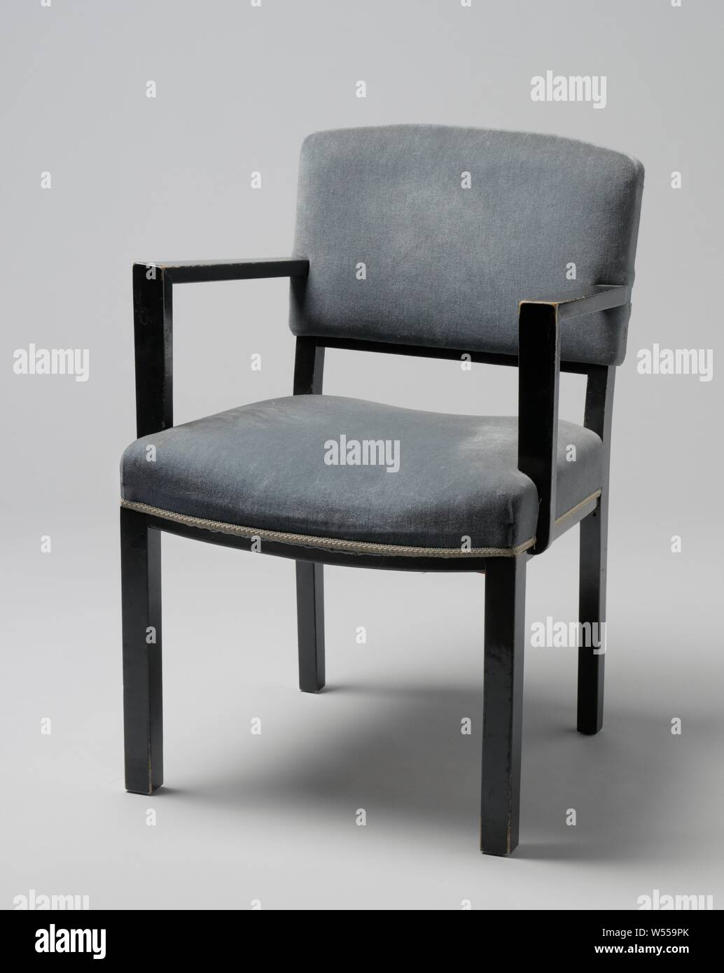 Poltrona con braccioli angolare e coperto con striscia blu, poltrona di nero laccato legno poggiante su quattro quadrati di gambe. Le zampe anteriori sono diritte e le zampe posteriori sono leggermente piegati e continuare nella parte posteriore POST. Il sedile è regolato in quattro linee le due linee laterali della quale sono dritte e la parte anteriore e la parte posteriore tubazioni piegate. La soglia inferiore dello schienale viene piegato. Piatto braccioli angolare correre verso il basso dal centro dello schienale e il resto davanti e non in linea con le gambe anteriori, sul piatto puntoni che sono parzialmente attaccata e in parte contro il sedile. Sia i corrimano e il sedile sono Foto Stock