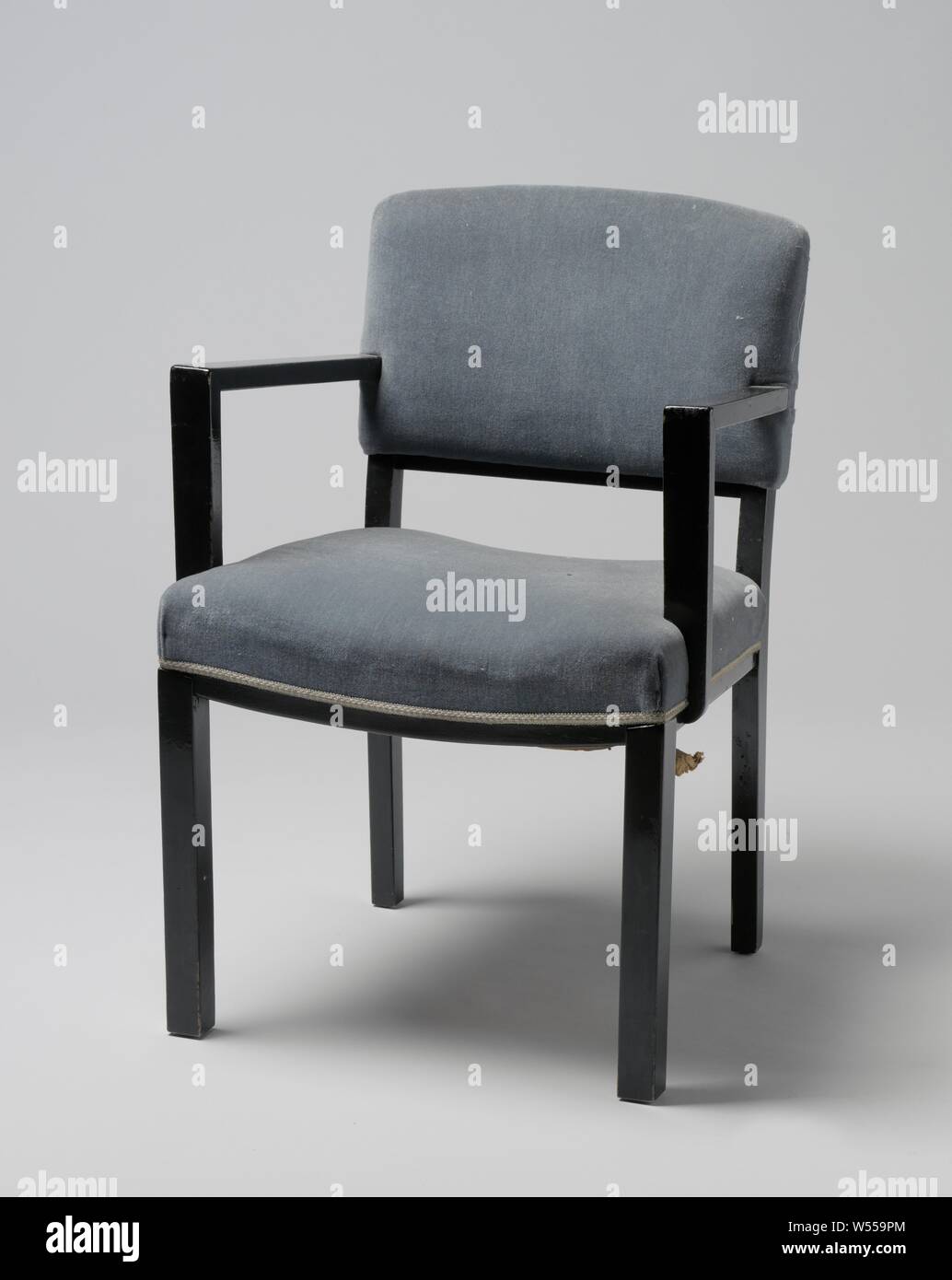 Poltrona con braccioli angolare e coperto con striscia blu, poltrona di nero laccato legno poggiante su quattro quadrati di gambe. Le zampe anteriori sono diritte e le zampe posteriori sono leggermente piegati e continuare nella parte posteriore POST. Il sedile è regolato in quattro linee le due linee laterali della quale sono dritte e la parte anteriore e la parte posteriore tubazioni piegate. La soglia inferiore dello schienale viene piegato. Piatto braccioli angolare correre verso il basso dal centro dello schienale e il resto davanti e non in linea con le gambe anteriori, sul piatto puntoni che sono parzialmente attaccata e in parte contro il sedile. Sia i corrimano e il sedile sono Foto Stock