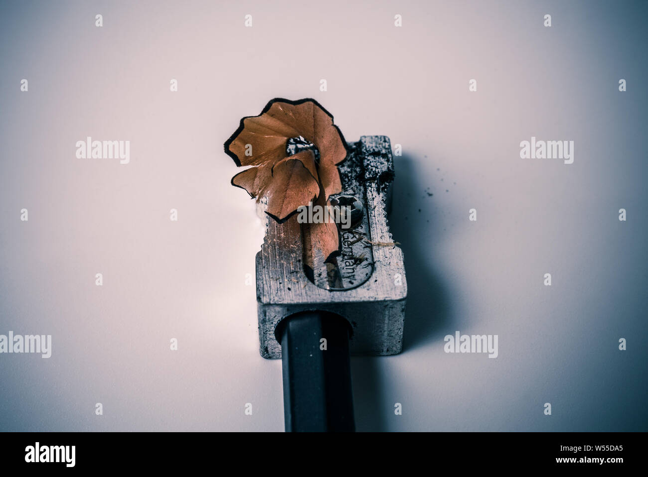 Macro closeup di affilatura di una matita con un metallo grigio temperamatite con legno di rasatura swirl - Concetto di istruzione scolastica, l'apprendimento e lo studente Foto Stock