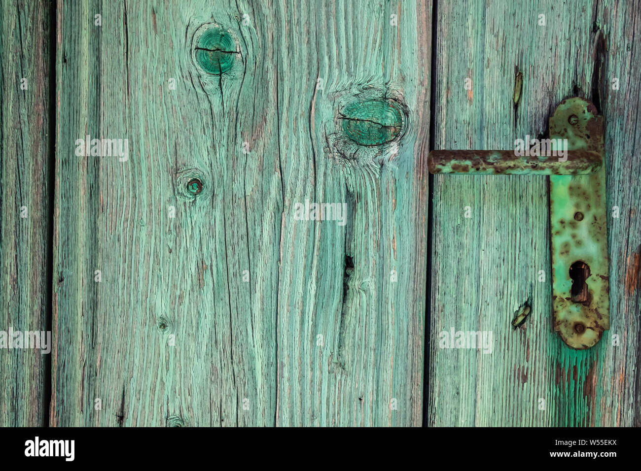 Antichi verde porta di legno respingente e ferro vintage maniglia della porta Foto Stock