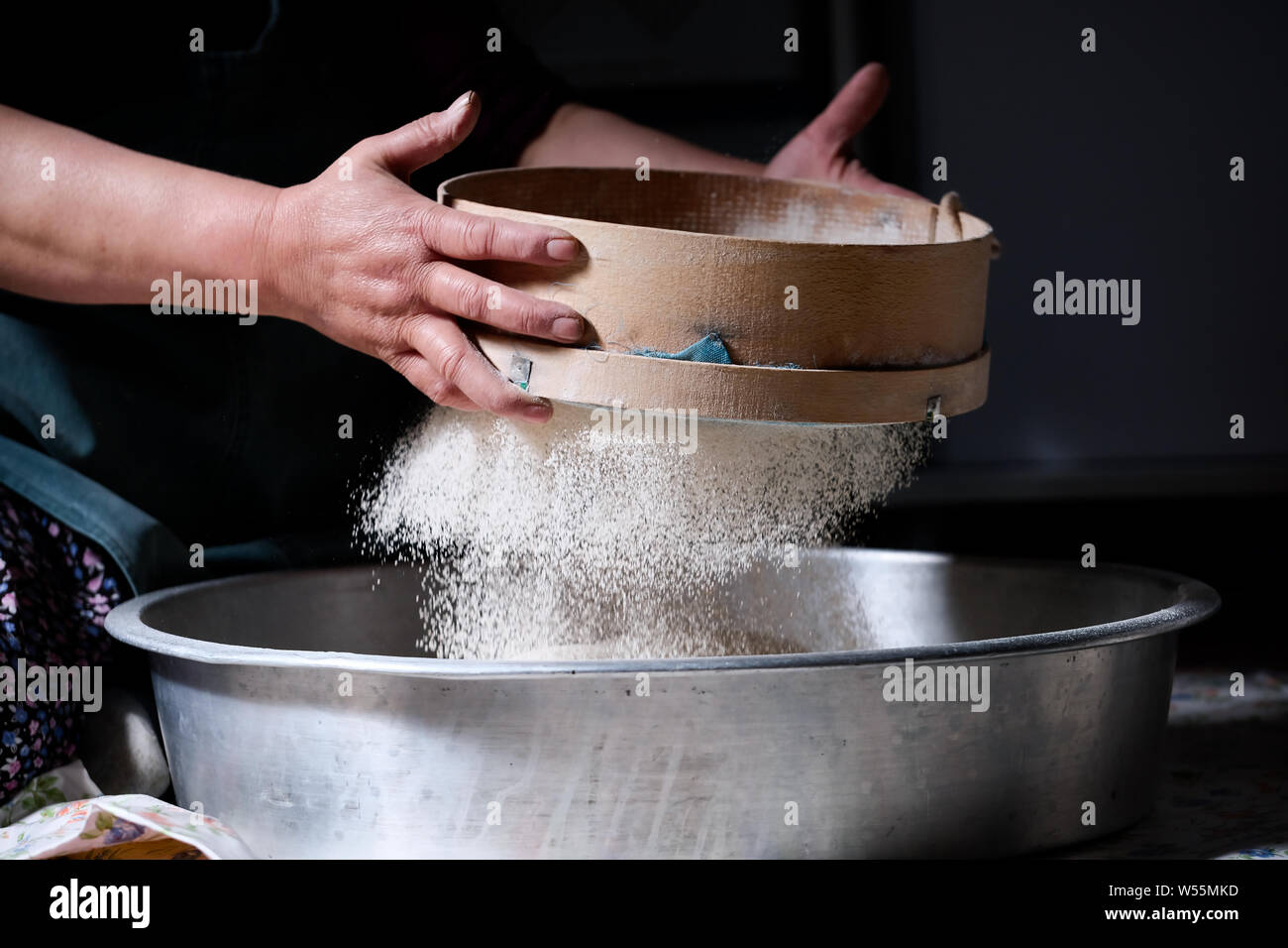 Lo chef donna vagliatura con le mani, setacciare la farina con il filtro di farina o di spolverizzatore Foto Stock