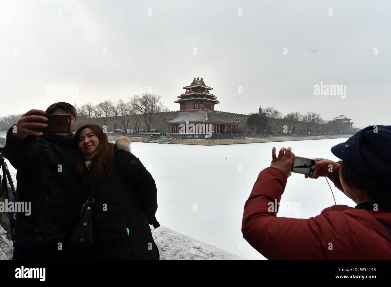 Gli appassionati di fotografia scattare foto della torretta presso il Museo del Palazzo, conosciuta anche come la Città Proibita, nella neve a Pechino in Cina, 14 febbraio Foto Stock