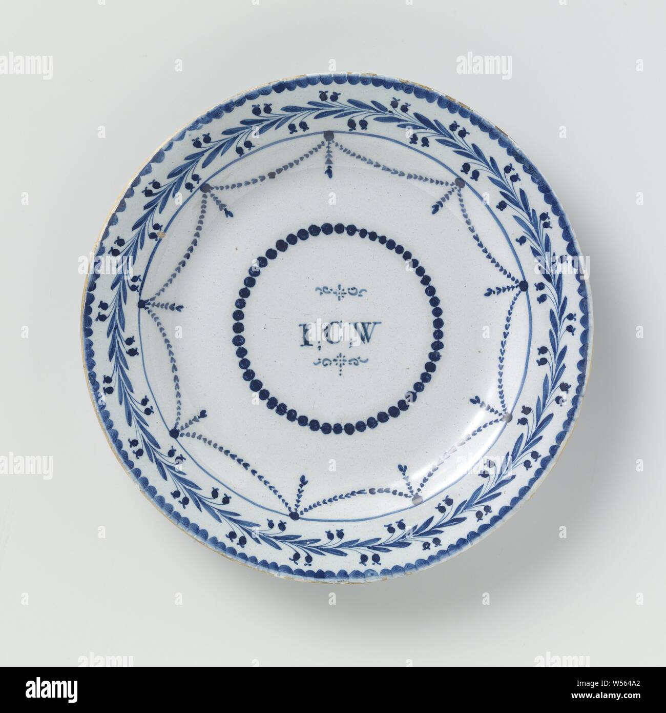 Piastra con le lettere I.C.W. e sul retro datata 1794, intorno alla piastra di blu maiolica dipinta. Sulla mensola sono le lettere I.C.W. entro un round collana di perle. verniciato e lungo il bordo del piatto ghirlande. Una ghirlanda di fiori e foglie è dipinto sul bordo. La piastra è datato sul retro: 1794., anonimo, Inghilterra, 1794, terraglia, stagno smalto, d 23,0 cm × h 2,8 cm Foto Stock