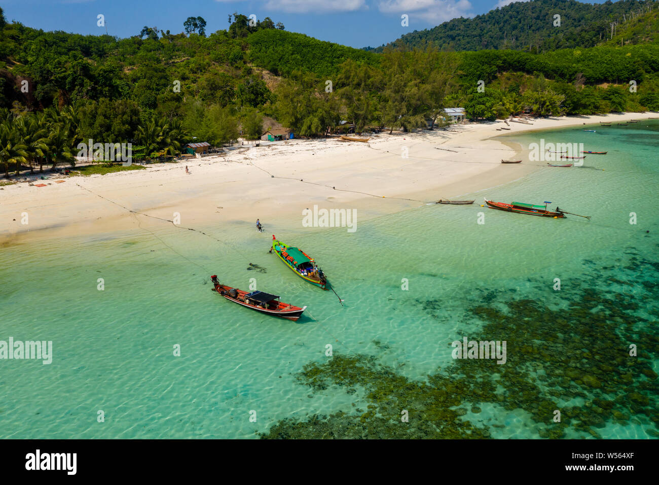 Antenna fuco vista longtail barche da pesca accanto ad una spiaggia di una piccola isola tropicale Foto Stock