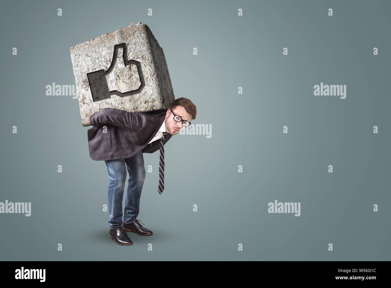 L'uomo flessione sotto un massiccio di pietra con un pulsante simile su di esso Foto Stock