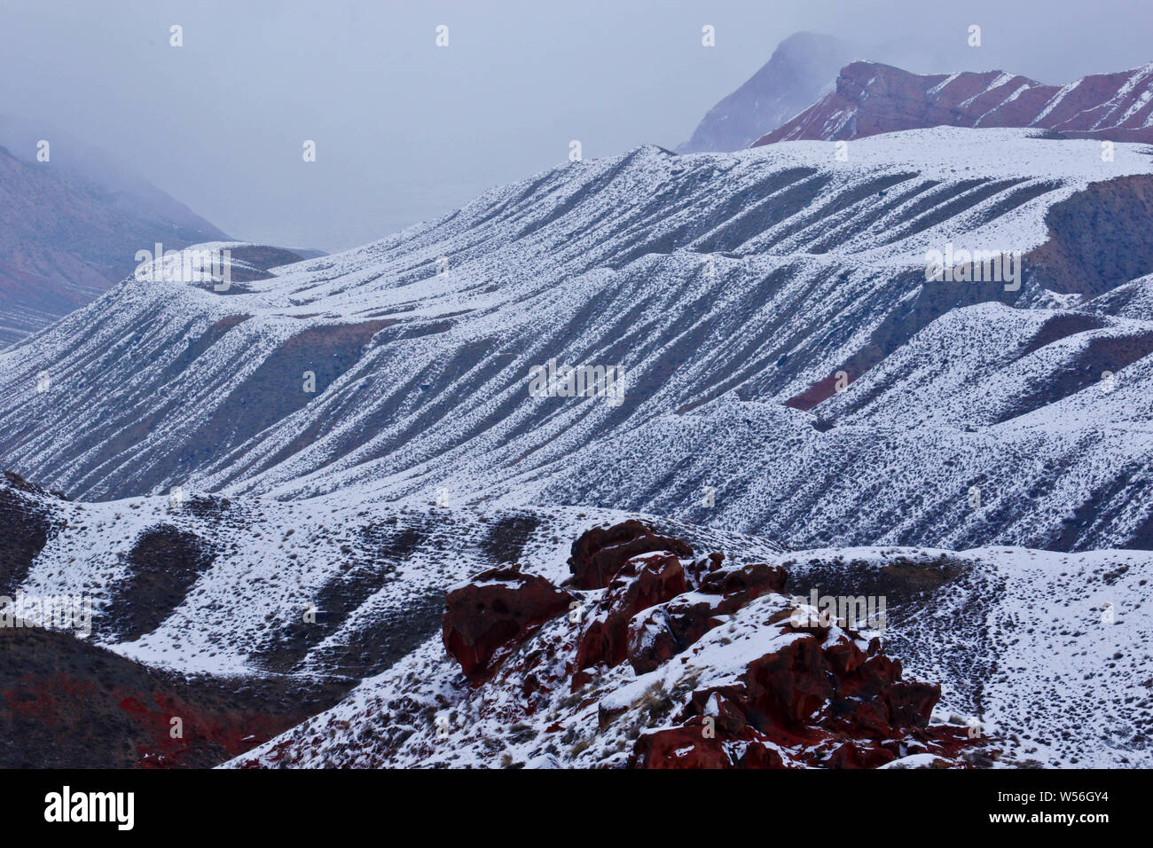 Il paesaggio di Danxia rilievi coperti di neve durante la festa di primavera o Capodanno lunare holiday in Sunan Yugur contea autonoma, Zhangye city Foto Stock