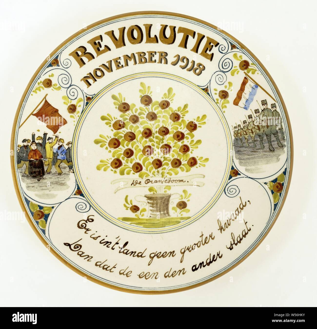 Targa commemorativa rivoluzione 'novembre 1918', targa commemorativa rivoluzione 'novembre 1918' del dipinto e terracotta invetriata, centro albero anteriore con foglie di colore verde e marrone e le mele in una pentola, con nastro con 'De Oranjeboom' su di esso. In cerchio con 5 linee colorate, sul confine al di sopra e al di sotto del testo, lasciato agire la folla di persone in semplice abito marrone con bandiera, gruppo di destra di uniformata e soldati armati con bandiera olandese, tutti in blu-incollati, telaio ricci, Paesi Bassi, Pieter Jelles Troelstra, Er è in 't Land geen kwaad grooter, Dan dat de een den ander slaat', anonimo, Gouda, 1918, terraglia Foto Stock