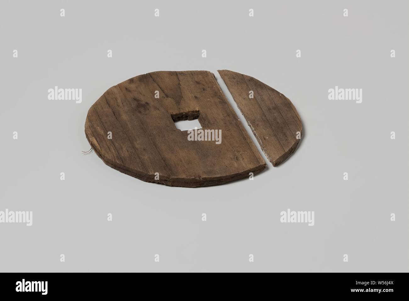 Disco per il materiale di imballaggio dalla nave V.O.C. Il 'Witte Leeuw", il disco per il confezionamento da V.O.C. Il disco ha un foro quadrato nel mezzo. Il disco è diviso in due, Saint Helena, olandese East India Company, anonimo, prima del 1613, il legno (materiale vegetale), d 9,4 cm × t 0,4 cm Foto Stock