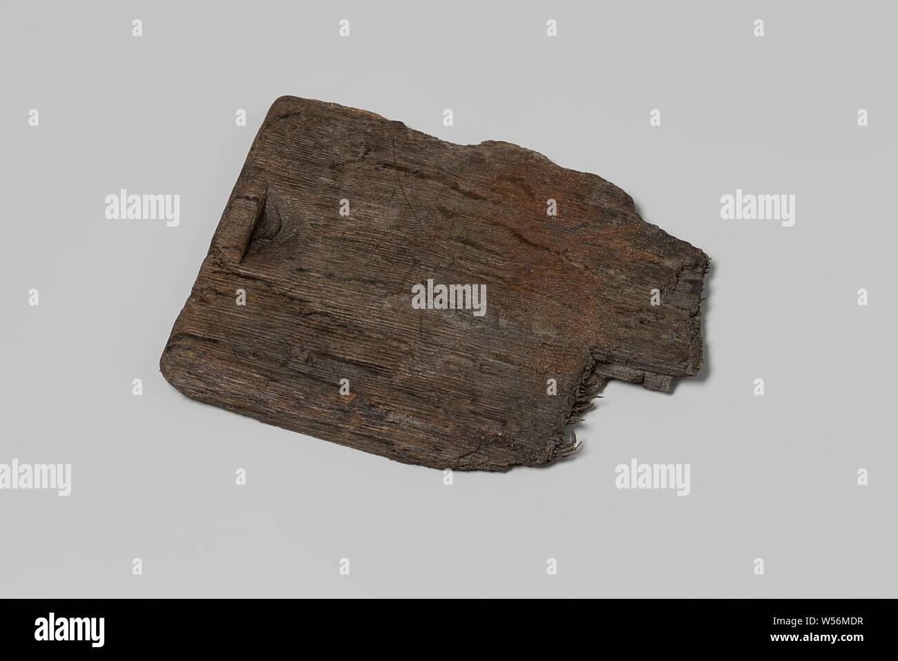 Il frammento del legno di un coperchio scorrevole dal relitto della Indie Orientali sailor 't Vliegend Hart, morto nel 1735. Il coperchio scorrevole è realizzato in legno di quercia. Si tratta di un pezzo piatto di legno con un incavo su un lato corto con il quale si poteva far scorrere il coperchio, quindi aprirlo. Il colore è marrone scuro / nero (vedere dimensioni), Olandese East India Company, 't Vliegend Hart (nave), 1700 - 1735, il legno (materiale vegetale), Rovere (legno), h 16.2 cm × W 12,8 cm × d 1 cm Foto Stock
