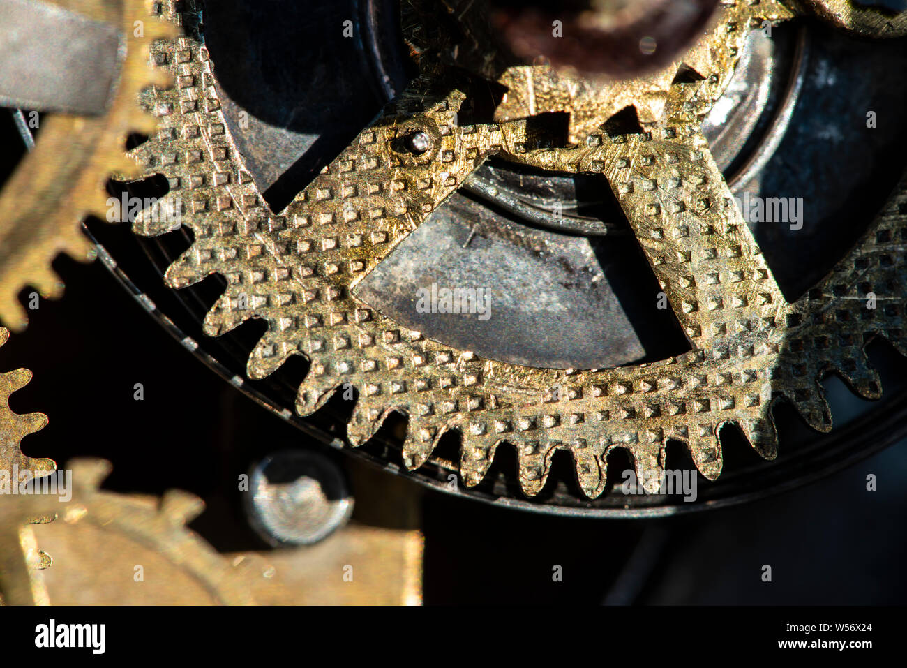 Close up ingranaggi metallici meccanismo. Colori dorati. Hard Light. Orologio meccanismo interno parti. Foto Stock