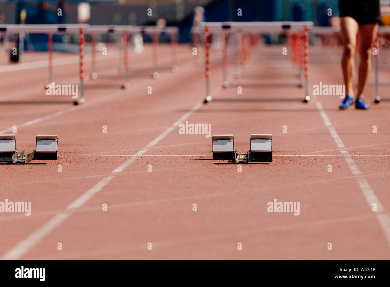 Blocchi di partenza di inizio esecuzione di 100 metri a ostacoli su atletica leggera Foto Stock