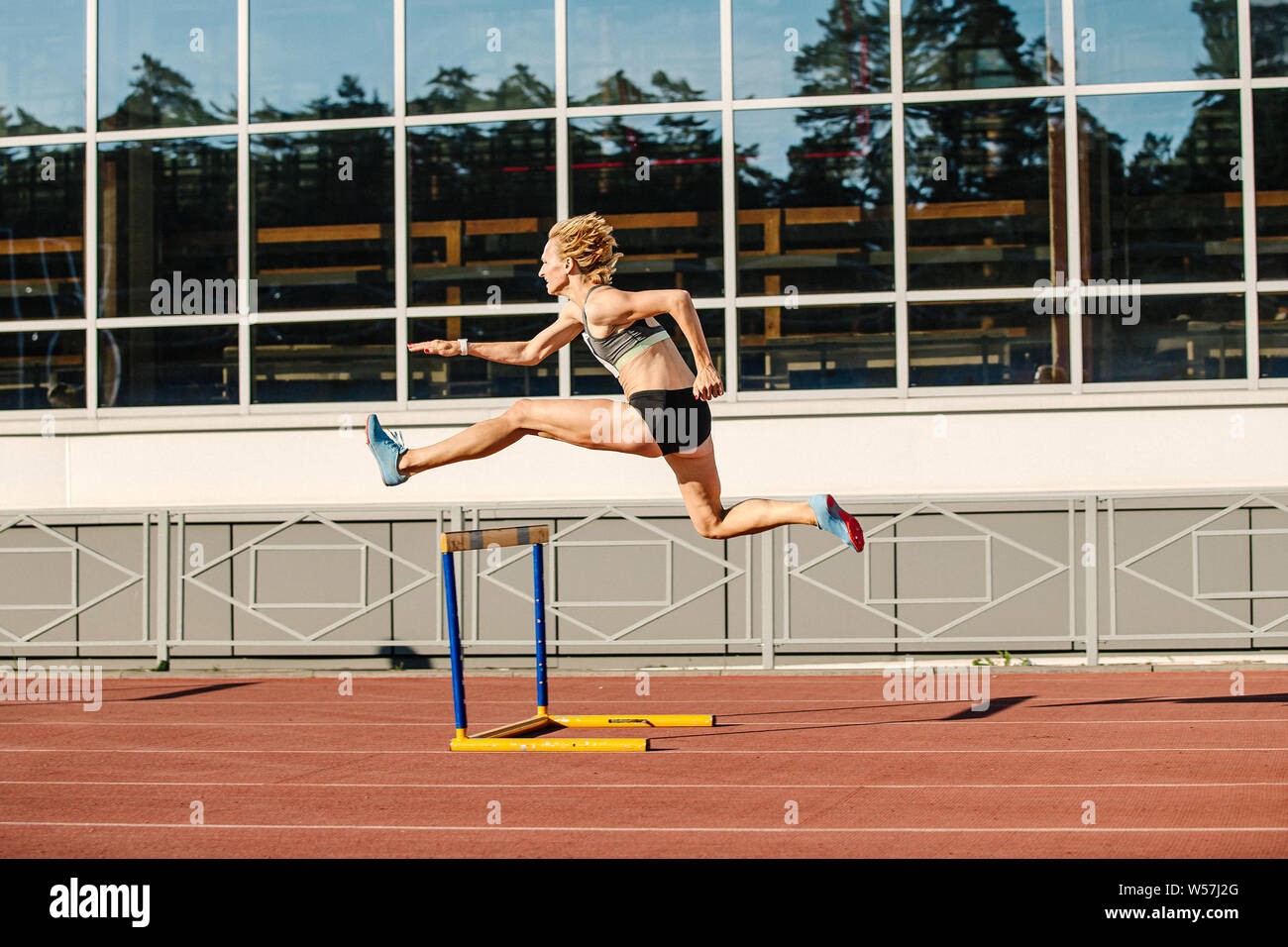 Donna atleta runnner ostacoli in esecuzione in estate le gare di atletica Foto Stock