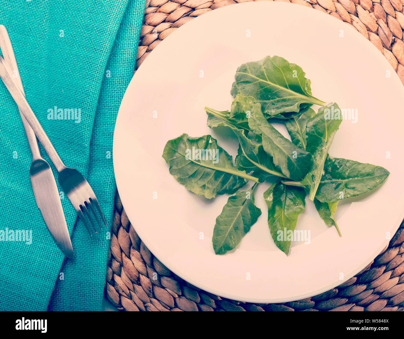 Un blando piastra bianca di trivellazione di foglie di insalata con retro Instagram stile effetto filtro Foto Stock