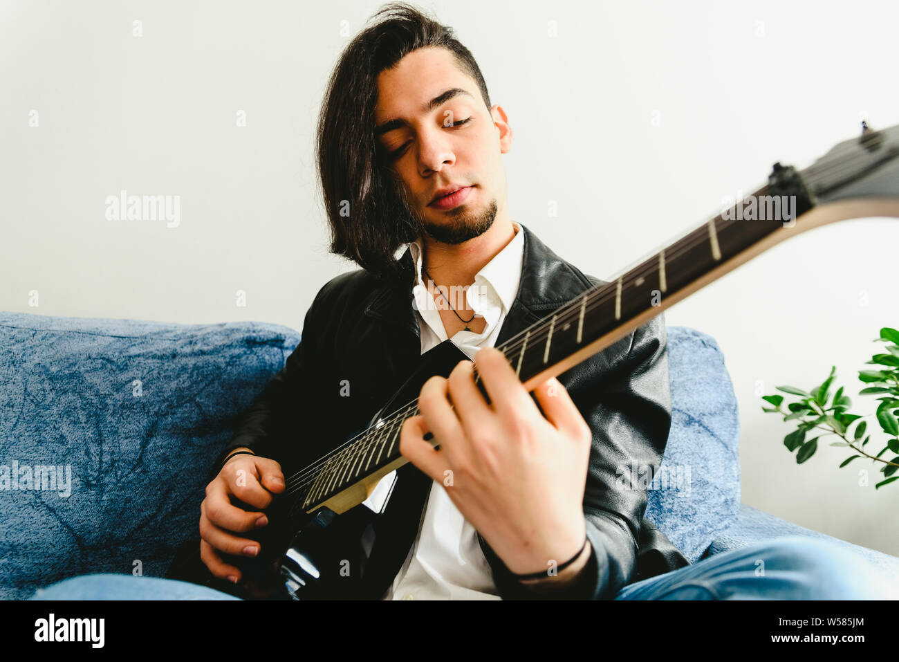 Chitarra elettrica maestro che insegna come posizionare le dita per suonare un accordo. Foto Stock