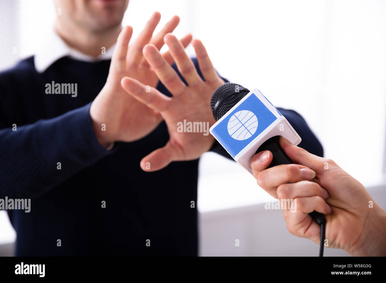 Close-up di femmina mano Reporter tiene in mano il microfono mentre l'uomo rifiuta intervista Foto Stock