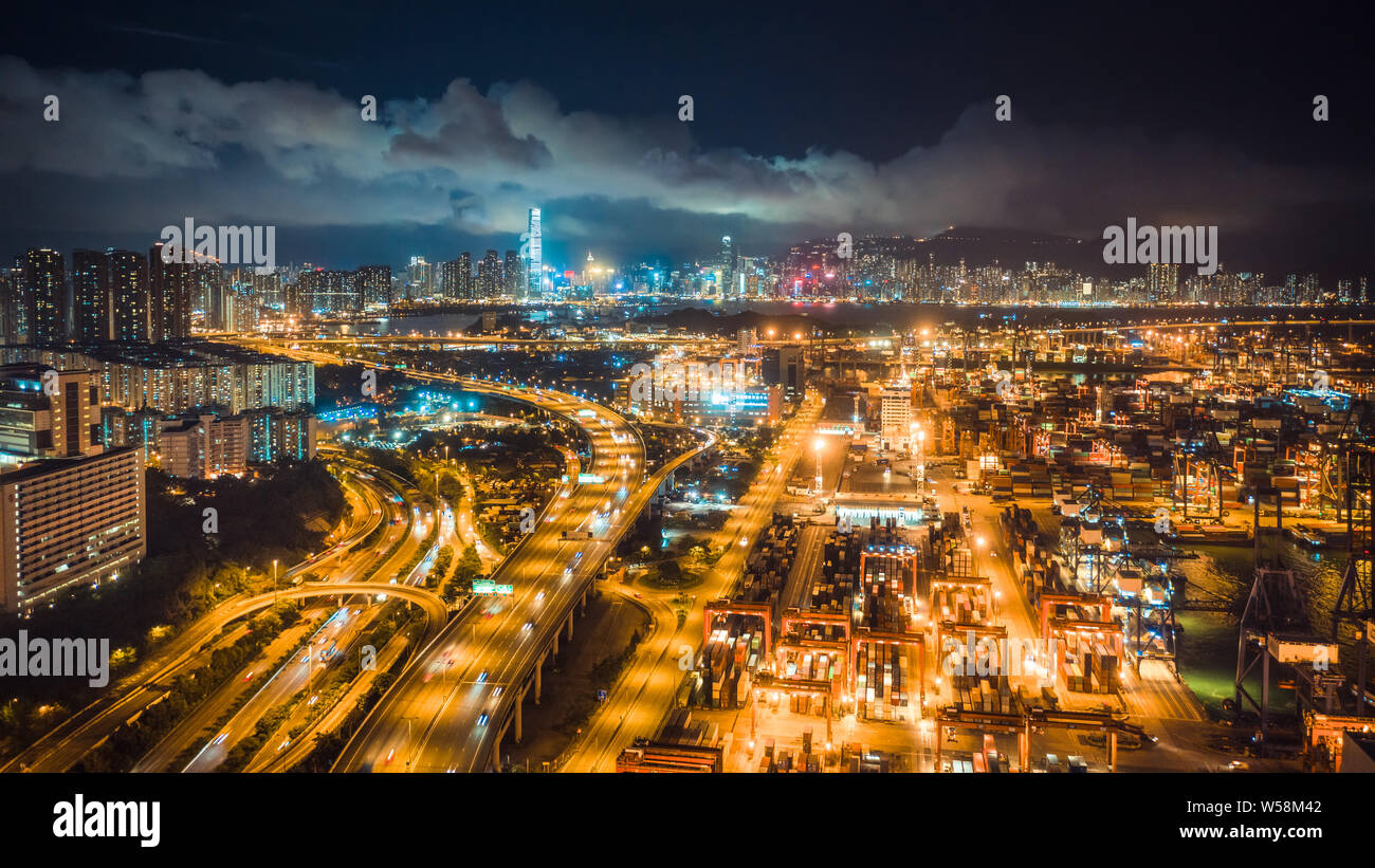 Porto di Hong Kong, il traffico autostradale e la Sinfonia di Luci mostra su edifici in città di notte. Asia turismo, destinazione di viaggio, business logistico Foto Stock
